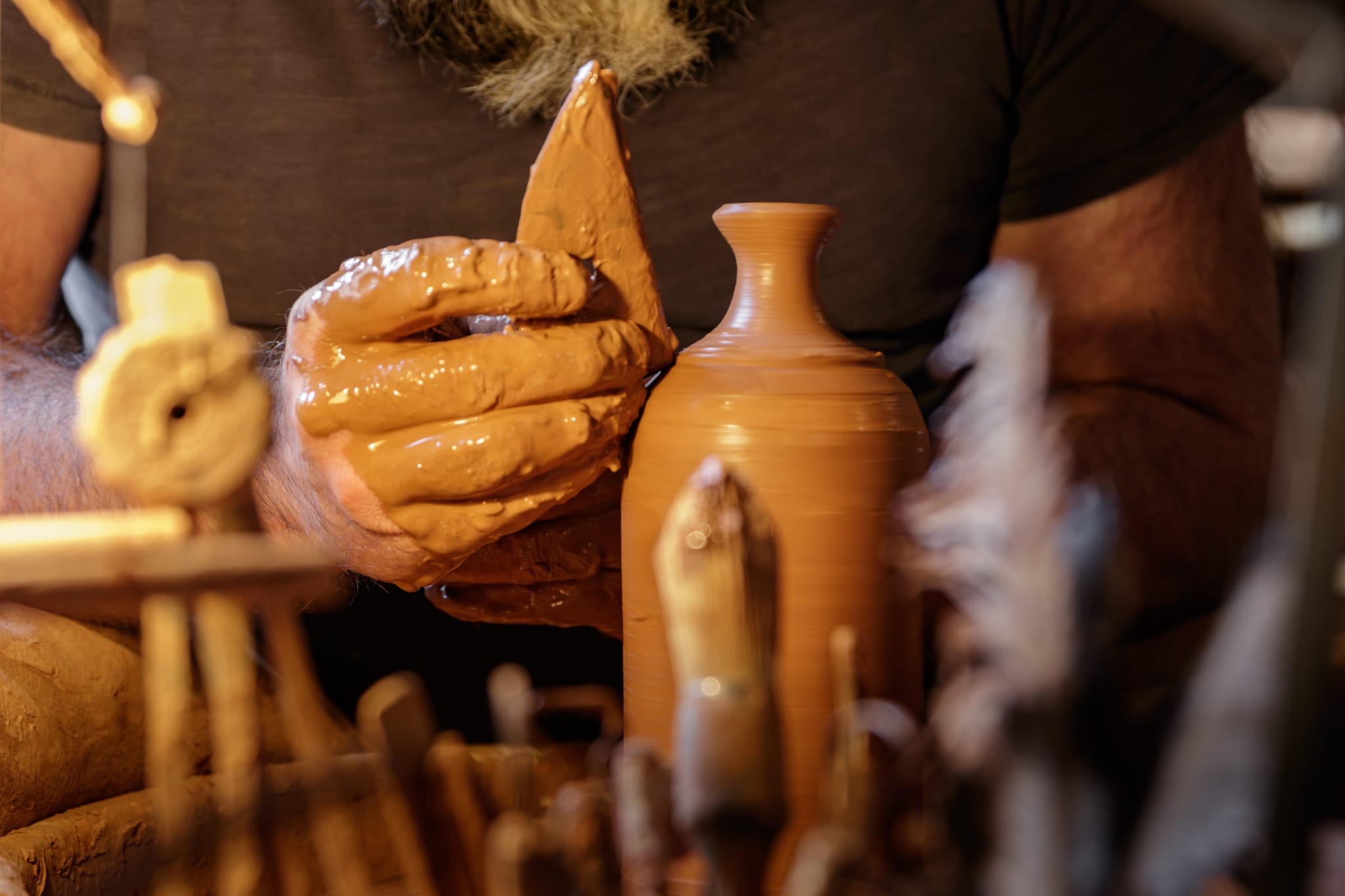 Peter Potter tournant une pièce en Grès de Noron dans son atelier
